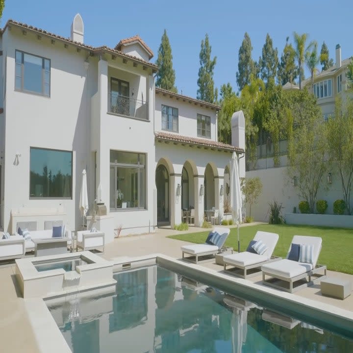 The backyard has a pool and a wide lawn