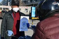 Volunteer holds a sign with a QR code in Suifenhe