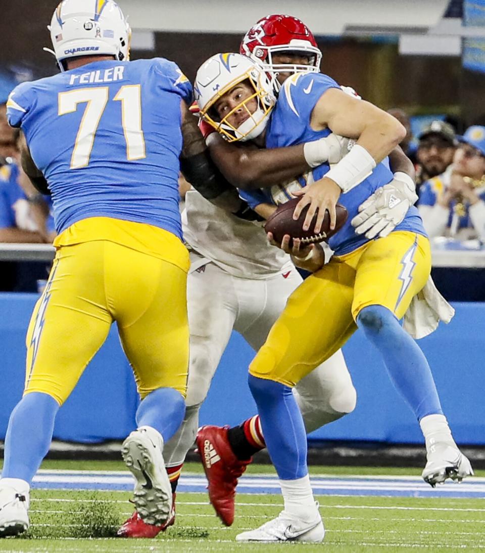 Chargers quarterback Justin Herbert (10) is tackled by Chiefs defensive tackle Chris Jones (95).