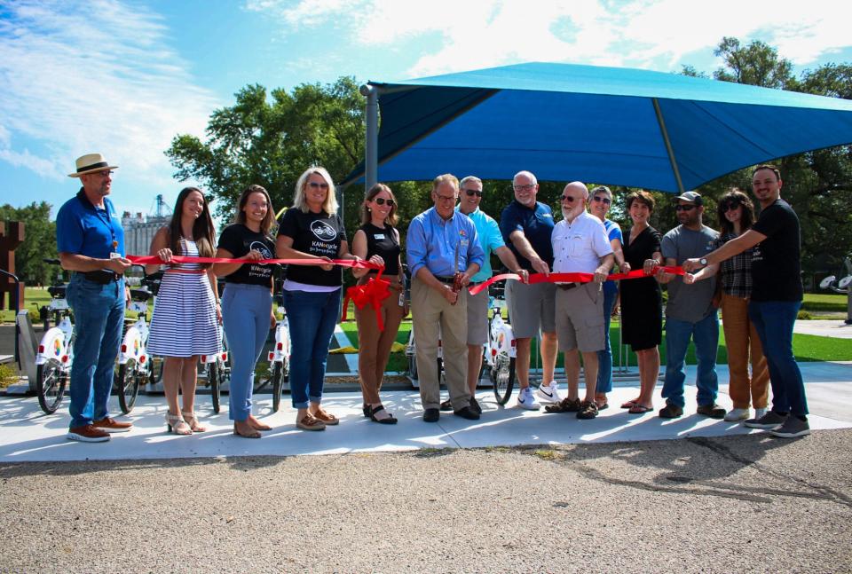 Lindsborg Mayor Clark Shultz and project partners participate in a ribbon-cutting for the KANcycle bike sharing program Friday at Fredricksen Family Fitness Park.