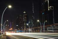 In this photo taken with a slow shutter speed, traffic speeds down the Sheikh Zayed Road in Dubai, United Arab Emirates, Monday, July 6, 2020. Dubai reopened for tourists Tuesday amid the coronavirus pandemic, hoping to reinvigorate a vital industry for this city-state before its crucial winter tourist season. (AP Photo/Jon Gambrell)