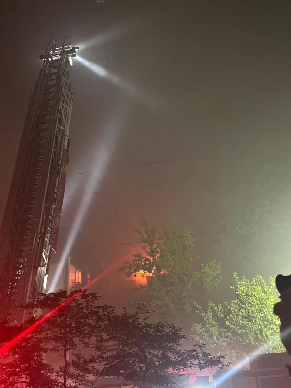 Orange flames are seen in an apartment building in Vancouver's Mount Pleasant neighbourhood after a fire broke out around 8:30 p.m. on July 28, 2023.