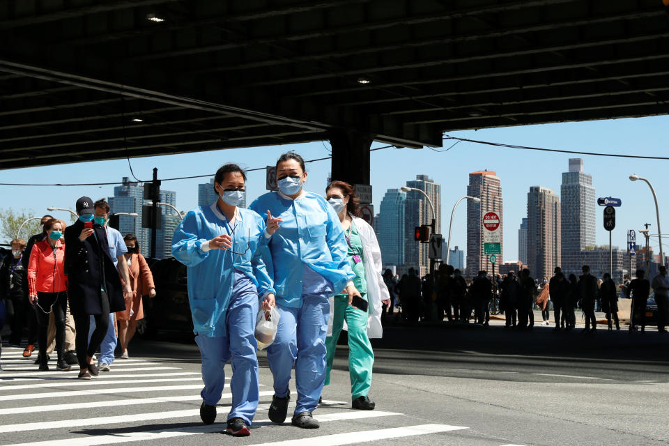 Healthcare workers from the NYU Langone Medical Center walk away after watching the U.S. Navy Blue Angels and U.S. Air Force Thunderbirds demonstration teams participate in a midday flyover of the New York City region as part of the "America Strong" tour of U.S. cities to honour first responders and essential workers during the outbreak of the coronavirus disease (COVID-19) in the U.S., April 28, 2020. REUTERS/Lucas Jackson