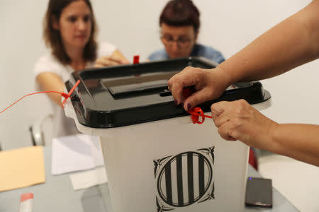 Voting officials seal a ballot box at a polling station for the banned independence referendum in Badalona, Spain, October 1, 2017. REUTERS/Susana Vera