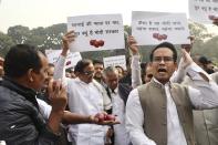 Indian lawmaker and former Finance Minister Palaniappan Chidambaram, center, holds a placard that reads "Why is the Modi government silent on the rise of onion prices, participates in a protest against the rise in onion prices, outside the Indian parliament in New Delhi, India, Thursday, Dec. 5, 2019. The former Indian finance minister just released on bail in a bribery case has joined a protest of the government’s economic policies, which are being blamed for India’s slowest economic growth in six years. (AP Photo/Manish Swarup)