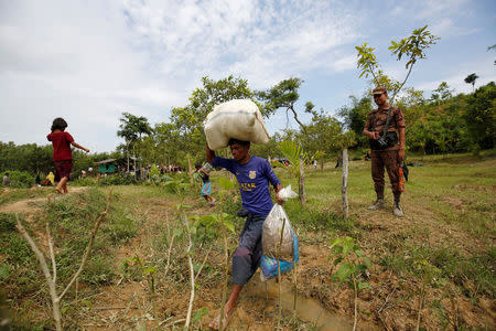 A Rohingya man returns to the No Man’s Land, with his belongings, from a makeshift shelter near the Bangladesh-Myanmar border, as the members of Border Guards Bangladesh (BGB) decided to push them back, in Cox’s Bazar, Bangladesh August 28, 2017. REUTERS/Mohammad Ponir Hossain