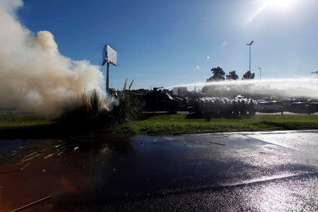 Anti-riot policemen use a water cannon to disperse protestors as they block a road during a 24-hour national strike in Buenos Aires, Argentina, April 6, 2017. REUTERS/Martin Acosta