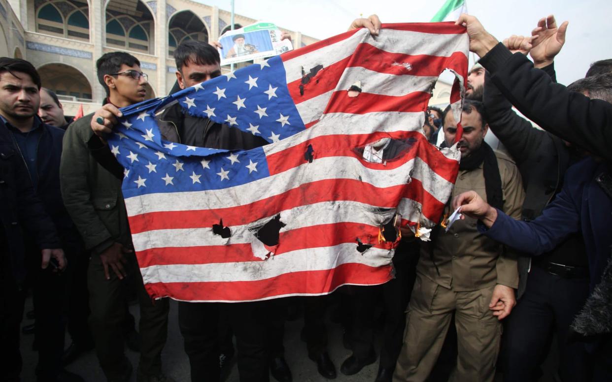 Iranians burn a US flag during a demonstration against the assassination in Tehran - AFP