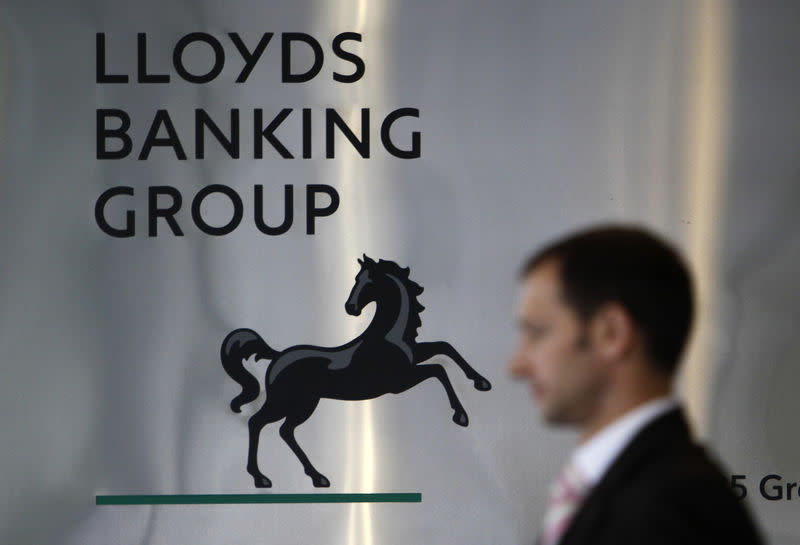 A pedestrian is seen passing the head office of the Lloyds Banking Group in central London in this August 5, 2009 file photograph. REUTERS/Stefan Wermuth/Files