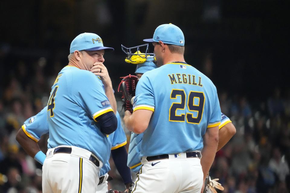 Milwaukee Brewers pitching coach Chris Hook, left, talks with pitcher Trevor Megill during a game at American Family Field last September.