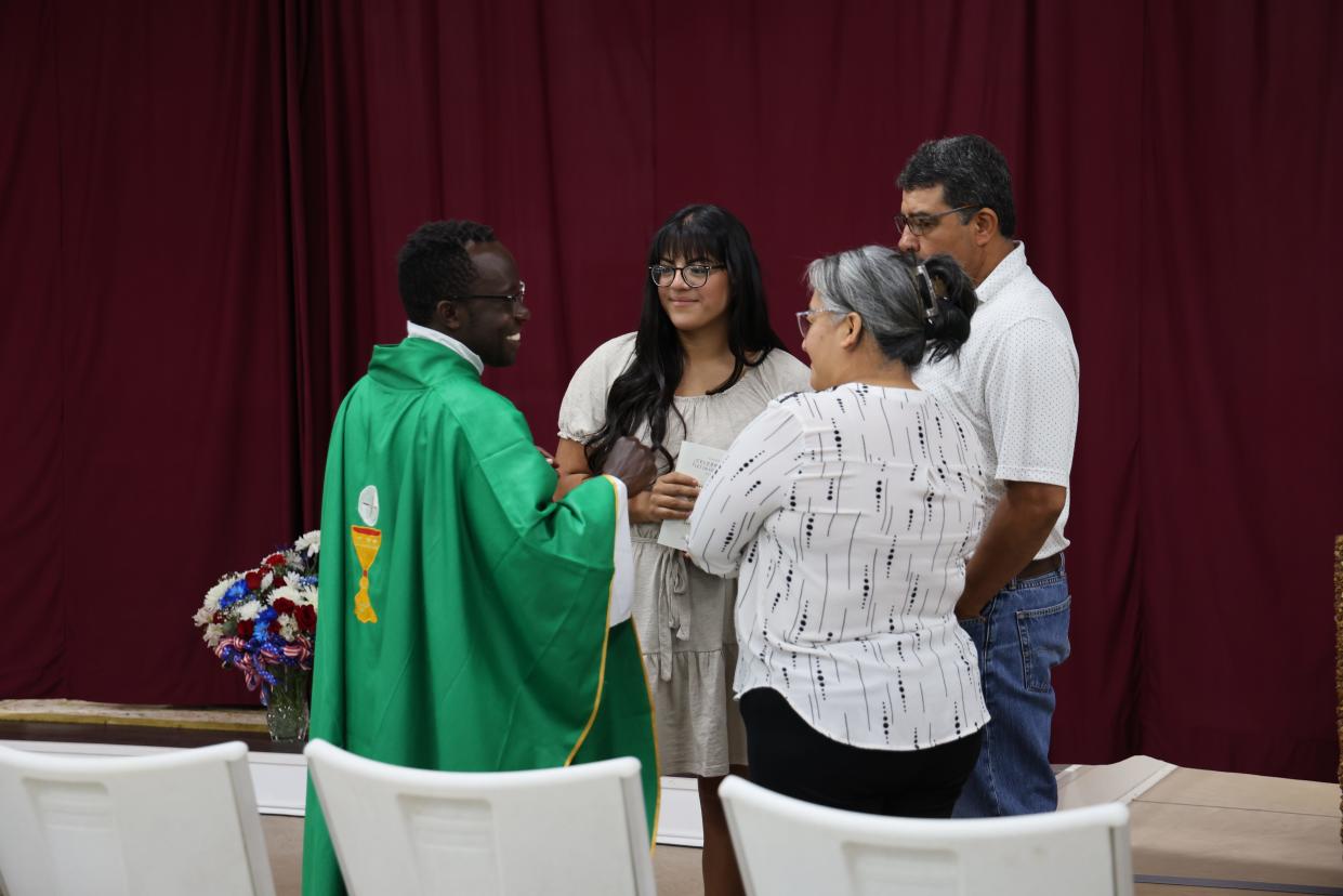 Father Kenn Wandera, a missionary priest from Kenya, talks with Catholics after Sunday mass at the parish he leads in the rural Appalachian town of Erwin, Tenn.