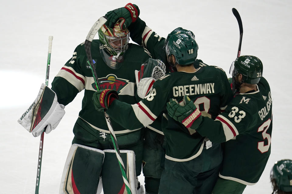 Minnesota Wild goaltender Filip Gustavsson, left, celebrates with teammates left wing Jordan Greenway, middle, and defenseman Alex Goligoski after defeating the New York Islanders 2-1 in a shootout of an NHL hockey game Tuesday, Feb. 28, 2023, in St. Paul, Minn. (AP Photo/Abbie Parr)