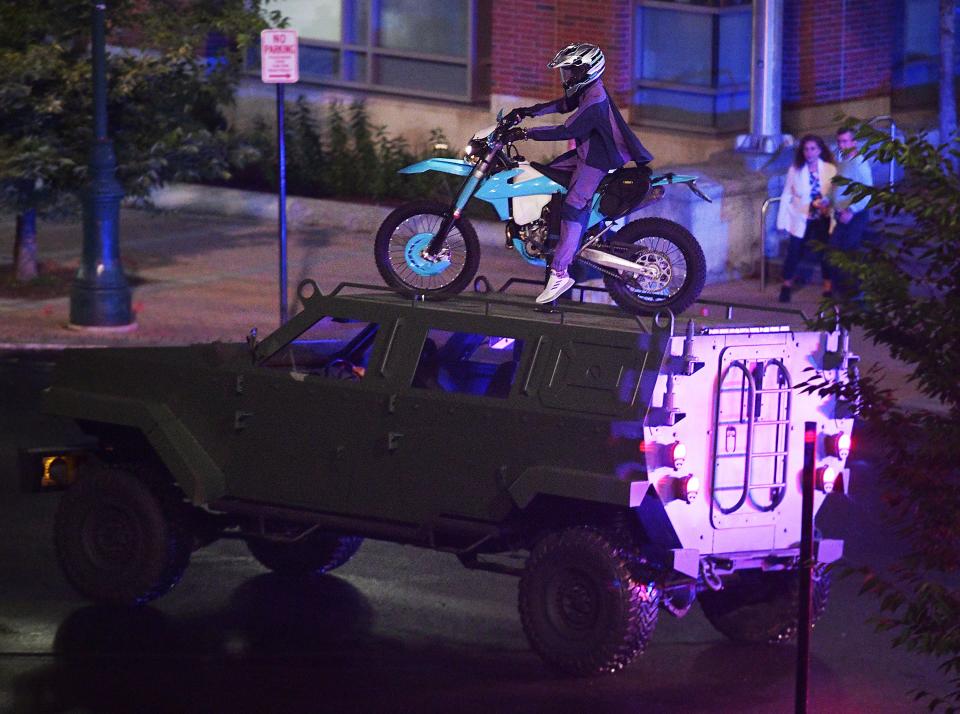 A mannequin riding a powder-blue motorcycle skids to a stop atop a Humvee during filming of “Black Panther: Wakanda Forever,” Aug. 25, 2021, in Worcester.
