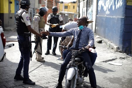 A protester shakes hands with a Haitian National Police (PNH) officer during a demonstration called by artists to demand the resignation of Haitian president Jovenel Moise, in the streets of Port-au-Prince