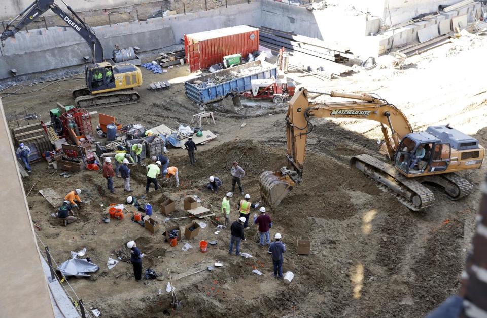 Workers excavate coffins from a construction site in the Old City neighborhood, Thursday, March 9, 2017, in Philadelphia. Crews working on an apartment building in Philadelphia's historic district got a shock last month when their backhoes started hitting coffins and unearthing fully intact human remains. The site was supposed to be a former burial ground from 1707, and all remains were supposedly exhumed in the 1800s and moved to a different cemetery. (AP Photo/Matt Slocum)