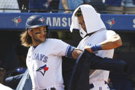 Toronto Blue Jays' Lourdes Gurriel Jr., right, puts The Blue Jacket on Bo Bichette after Bichette's two-run home run in the first inning of a baseball game against the Minnesota Twins in Toronto on Sunday, Sept. 19, 2021. (Jon Blacker/The Canadian Press via AP)