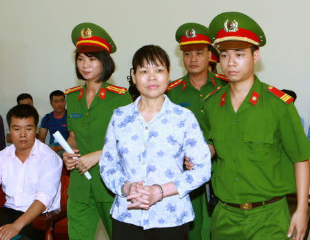 Can Thi Theu, a farmer and land protection activist (C) is escorted by policemen at a court in Hanoi, Vietnam September 20, 2016. Mandatory credit VNA/Doan Tan/via REUTERS