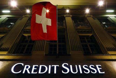 The logo of Swiss bank Credit Suisse is seen below the Swiss national flag at a building in the Federal Square in Bern May 15, 2014. REUTERS/Ruben Sprich