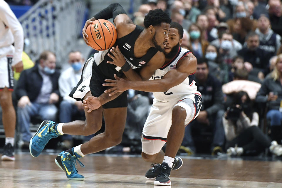 Providence's Al Durham (1) dribbles as Connecticut's R.J. Cole defends, in the first half of an NCAA college basketball game, Saturday, Dec. 18, 2021, in Hartford, Conn. (AP Photo/Jessica Hill)