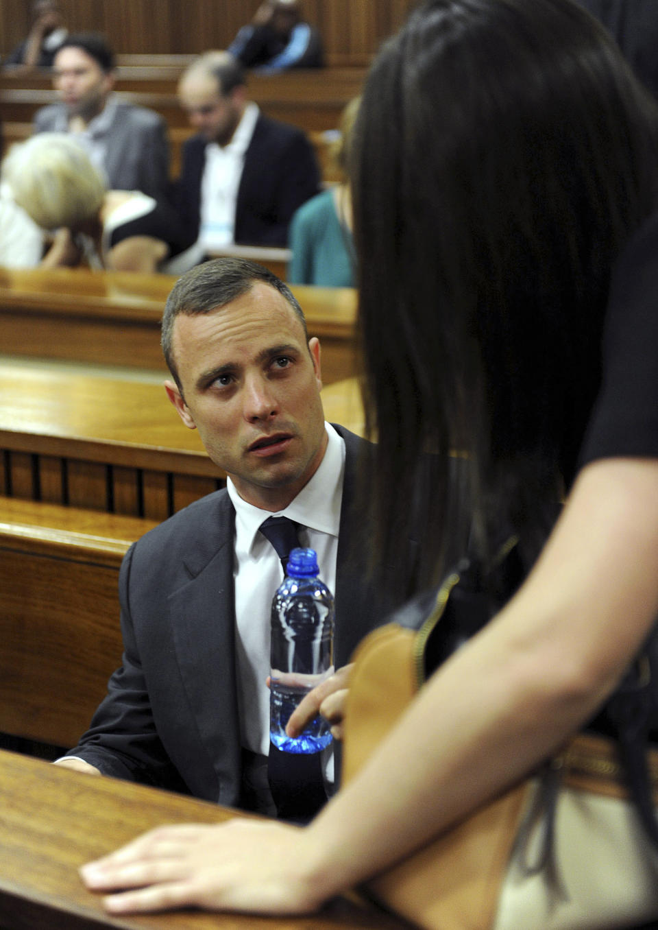 Oscar Pistorius talks to his sister, Aimee Pistorius, before the proceedings get under way at the high court in Pretoria, South Africa, Monday, March 24, 2014. The trial of Pistorius, who is charged with murder for the shooting death of his girlfriend Reeva Steenkamp on Valentines Day in 2013, is beginning its fourth week. (AP Photo/Chris Collingridge, Pool)