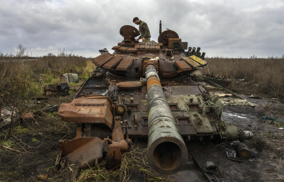 A Ukrainian soldier inspects a Russian tank in that was damaged in recent fighting near the recently retaken village of Kamianka, Kharkiv region, Ukraine, Sunday, Oct. 30, 2022.(AP Photo/Efrem Lukatsky)