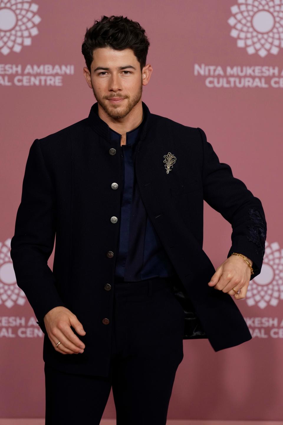 Nick Jonas is oh-so-suave in a navy blue top and black suit.