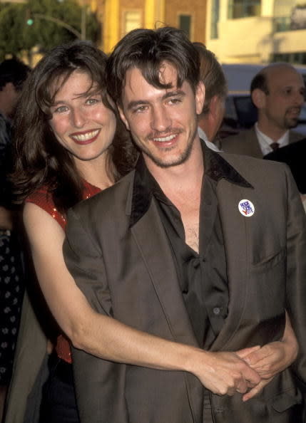 Catherine Keener hugs Dermot Mulroney from behind