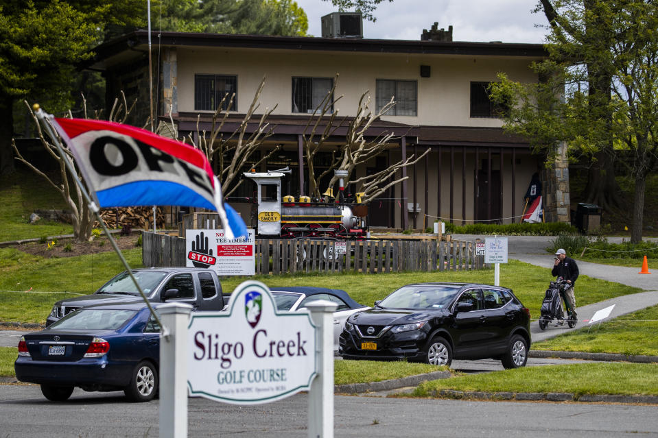 A golfers, right, walks at the Sligo Creek Golf Course in Silver Spring, Md., Monday, May 11, 2020, as Maryland Gov. Larry Hogan opened golf courses in the initial stage in easing coronavirus shutdown. As states push for some return to normal business operations, elected officials in the Virginia and Maryland suburbs surrounding Washington, D.C., are unwilling to quickly reopen, as they confront COVID-19 infection and fatality numbers that are the highest in their states. (AP Photo/Manuel Balce Ceneta)