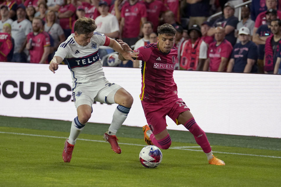 Vancouver Whitecaps' Ryan Gauld, left, and St. Louis City's Celio Pompeu battle for the ball during the second half of an MLS soccer match Saturday, May 27, 2023, in St. Louis. (AP Photo/Jeff Roberson)