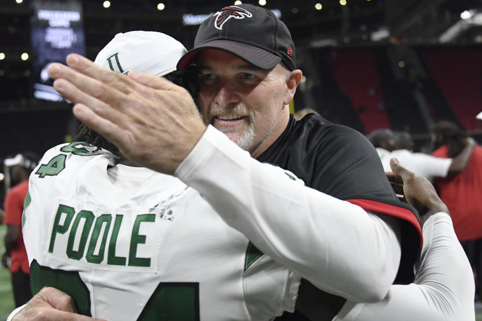 Atlanta Falcons head coach Dan Quinn embraces New York Jets cornerback Brian Poole (34) after the second half an NFL preseason football game, Thursday, Aug. 15, 2019, in Atlanta. (AP Photo/John Amis)