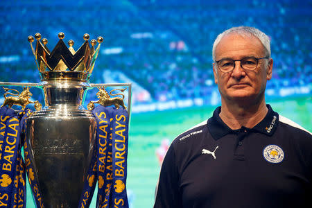 Football club Leicester City manager Claudio Ranieri stands on stage next to the club's English Premier League trophy during a meeting with the media in Bangkok, Thailand May 18, 2016. REUTERS/Jorge Silva