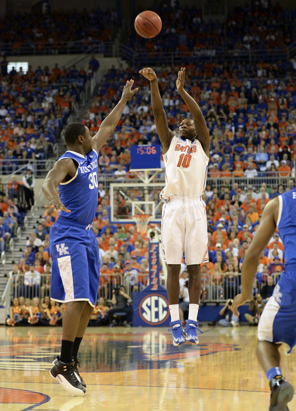 Florida forward Dorian Finney-Smith (10) shoots for 3- points as Kentucky forward Kentucky forward Julius Randle (30) defends during the first half of an NCAA college basketball game Saturday, March 8, 2014, in Gainesville, Fla. (AP Photo/Phil Sandlin)