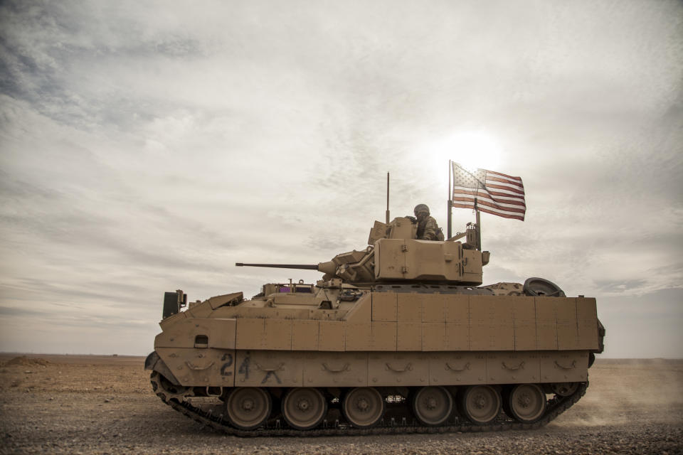 FILE - American soldiers drive a Bradley fighting vehicle during a joint exercise with Syrian Democratic Forces at the countryside of Deir Ezzor in northeastern Syria, Dec. 8, 2021. The U.S. and Germany are sending Ukraine an array of armored vehicles, including 50 tank-killing Bradleys, to expand its ability to move troops to the front lines and beef up its forces against Russia as the war nears its first anniversary. (AP Photo/Baderkhan Ahmad, File)