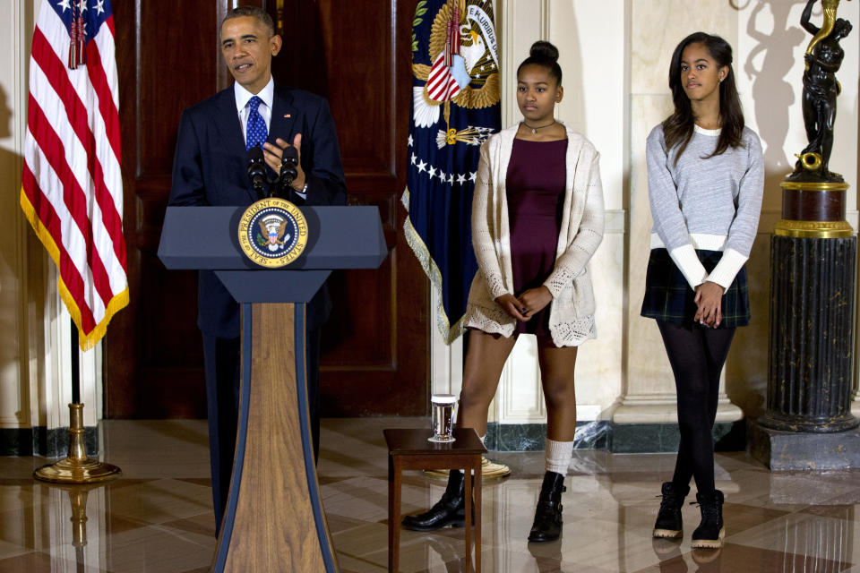 President Barack Obama, joined by his daughters Malia and Sasha, speaks at the White House on Nov. 26, 2014, during the presidential turkey pardon ceremony, an annual Thanksgiving tradition. (AP Photo/Jacquelyn Martin)