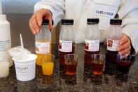 FILE PHOTO: A technician displays bottles containing prototype fruit juice drinks at the Tate & Lyle European Innovation Centre in Villeneuve d'Ascq, France, September 26, 2018. REUTERS/Pascal Rossignol