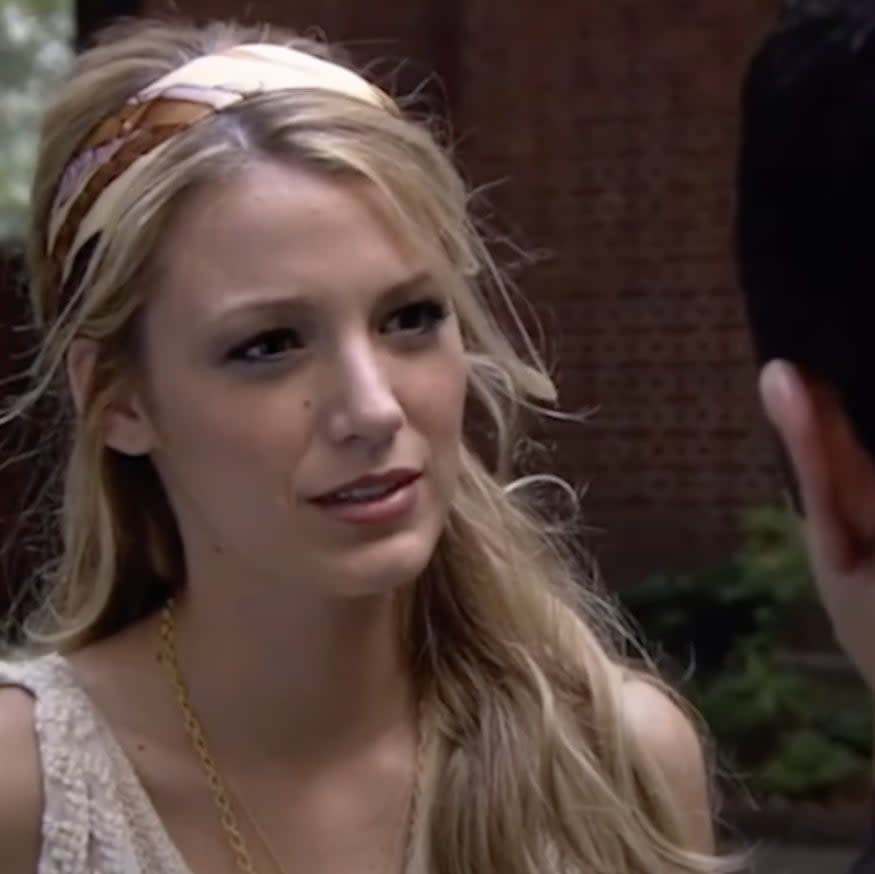 Blake Lively in a scene from Gossip Girl, wearing a sleeveless top and a headband, facing and talking to another person whose back is turned to the camera