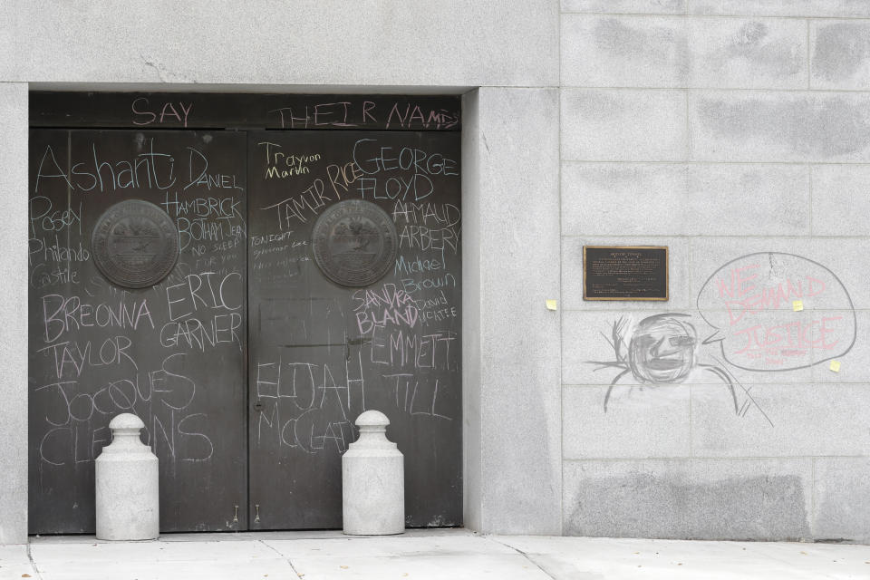 Graffiti from demonstrators protesting social injustice is left on doors and a wall at the state capitol Wednesday, July 1, 2020, in Nashville, Tenn. Tennessee's newest law, a wide range of crimes commonly associated with protests will see a big bump in penalties and fines, but the most contentious element focuses on escalated penalties for "illegal camping" on state property from a misdemeanor to a felony, punishable by up to six years in prison. (AP Photo/Mark Humphrey)