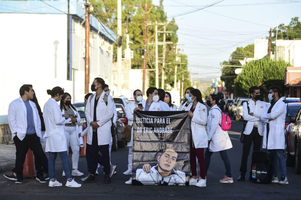 Students protest, some holding a banner.