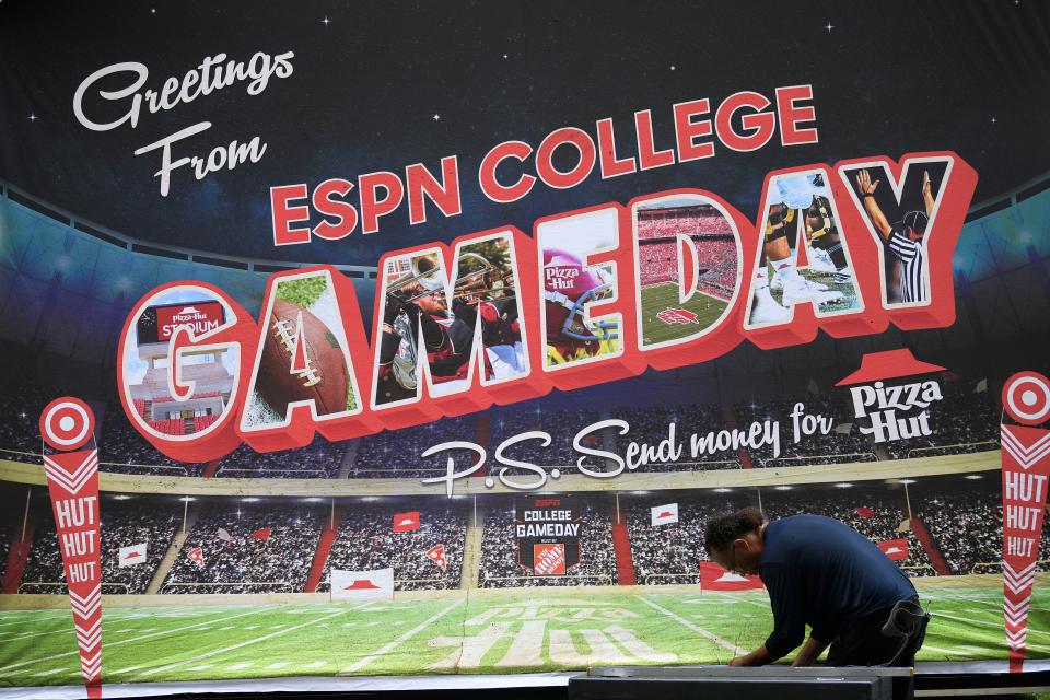 A worker sets up a banner for ESPN's College GameDay show in front of Ayres Hall in Knoxville, Tenn. on Thursday, Sept. 22, 2022. ESPN's flagship college football pregame show is returning for the tenth time to Knoxville as the No. 12 Vols face the No. 22 Gators on Saturday. The show will air Saturday from 9 a.m. to noon ET.