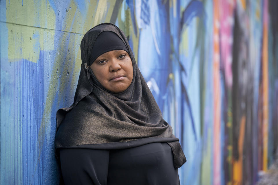 Asiyah Timimi, whose husband was stabbed to death in January 2021, stands along the murals on Metropolitan Branch Trail on Friday, Oct. 27, 2023 in Washington. (AP Photo/Kevin Wolf)