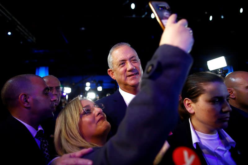 Blue and White party leader Benny Gantz poses for a picture with a supporter after speaking to supporters following the announcement of exit polls in Israel's election at the party's headquarters in Tel Aviv