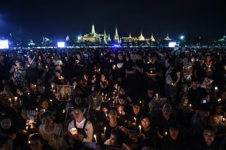 People light candles in honour of the late Thai King Bhumibol Adulyadej to commemorate his birthday in Sanam Luang park, in front of the Grand Palace in Bangkok, on December 5, 2016