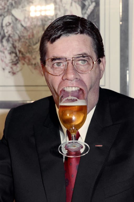Jerry Lewis holds a glass of beer with his mouth in 1987 in Paris