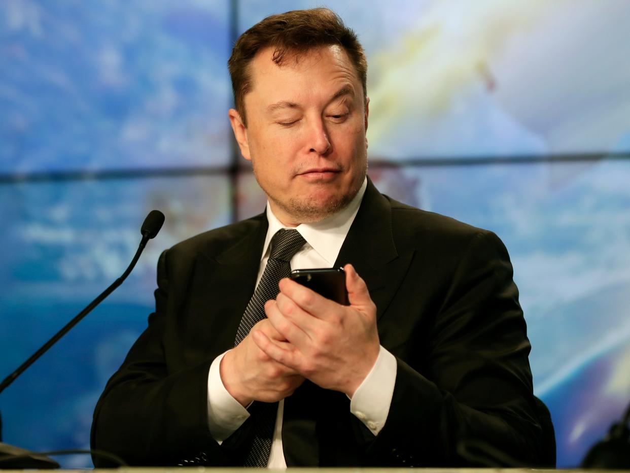 Elon Musk looking at his phone.