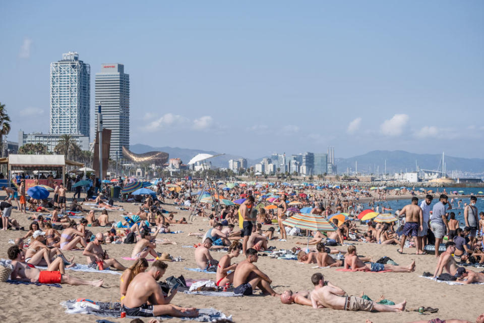 Hundreds of people are seen sunbathing at the Barceloneta beach on Saturday despite the government's warning to stay home.