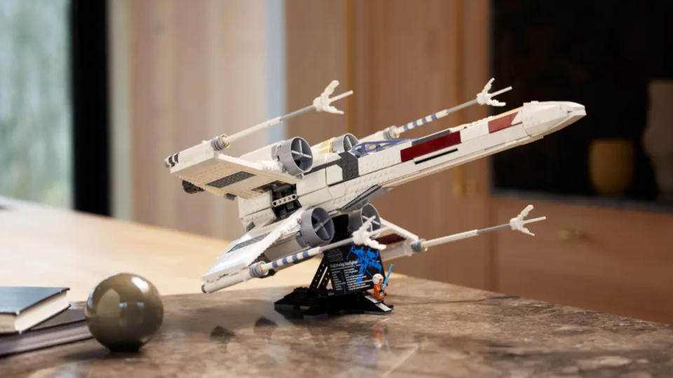 The UCS X-Wing set up on a stand on a marble table