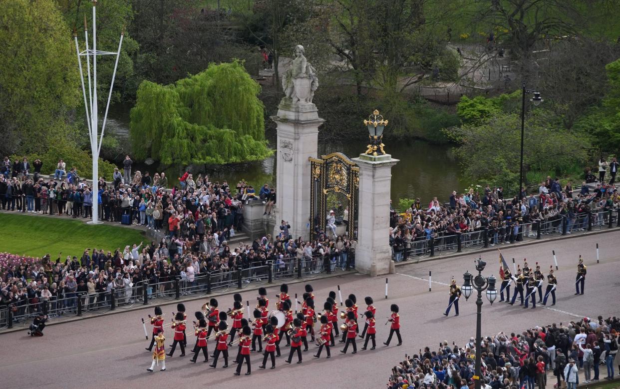 British and French troops march past crowds outside St James's Park opposite Buckingham Palace