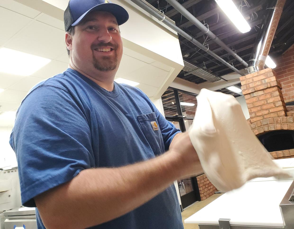 Tyler Prevatte, one of the owners of Pour Folk Provisions in Lexington, practices stretching the eatery's homemade pizza dough to cook in its new brick pizza oven. The restaurant will begin selling Neapolitan pizza pies on Feb. 25.