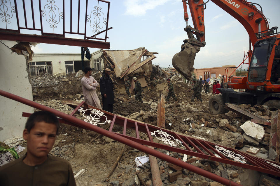 Soldiers and civilians search for bodies after a mudslide caused by heavy flooding, in Parwan province, north of Kabul, Afghanistan, Wednesday, Aug. 26, 2020. The flooding in northern Afghanistan killed and injured dozens of people officials said Wednesday. (AP Photo/Rahmat Gul)