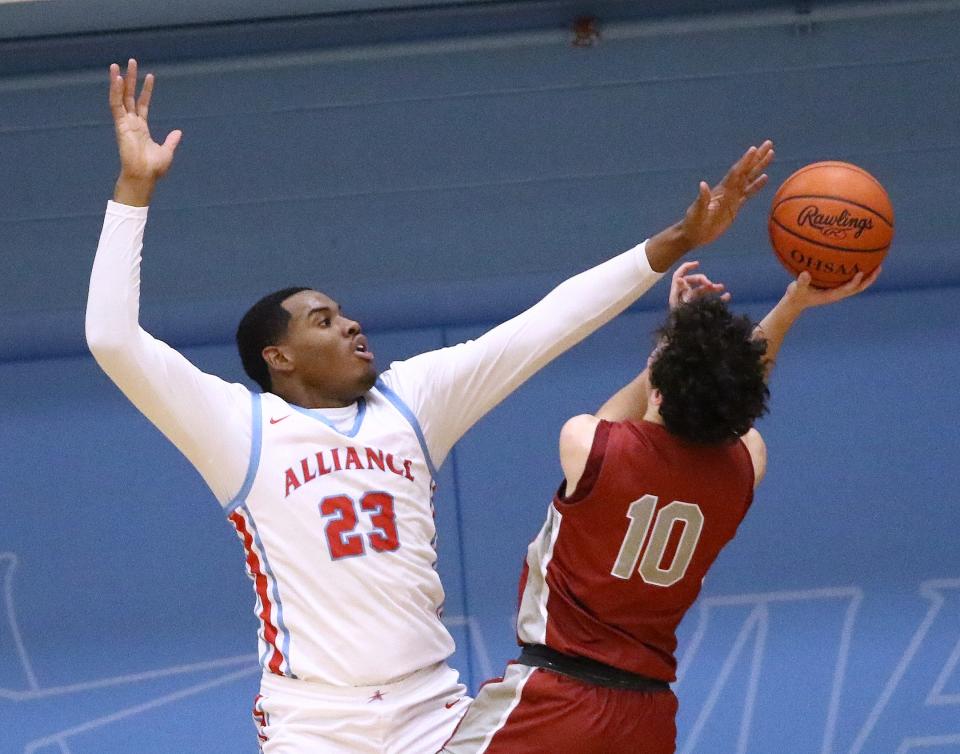 Alliance's Diego Allen, left, defends against a shot by Dover's Tyler Stevenson (10) during action at Alliance High School on Tuesday, January 17, 2023.